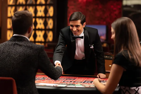 CROWNDB — A high-class gaming experience without limits A woman in a luxurious green gown next to an ornate roulette wheel, capturing the upscale casino mood of CROWNDB.